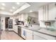 Bright kitchen with stainless steel appliances, white cabinets, and open layout to dining area at 13889 N 108Th Dr, Sun City, AZ 85351