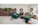 Cozy living room featuring a decorative fireplace, full bookshelves, and comfortable green couches at 13889 N 108Th Dr, Sun City, AZ 85351