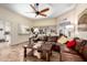 Open living room with a leather sectional, built-in shelves, and a pass-through to the kitchen at 13889 N 108Th Dr, Sun City, AZ 85351