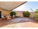 Covered patio features brick pavers, comfortable seating, and mature landscaping at 13889 N 108Th Dr, Sun City, AZ 85351