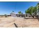 Desert landscaped backyard featuring a white house with green trees and succulents at 1413 E Dobbins Rd, Phoenix, AZ 85042