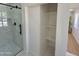 A bathroom featuring a shower with a glass door and marble tile surround plus built-in storage at 1421 W Pasadena Ave, Phoenix, AZ 85013