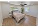 Comfortable bedroom with large window, ceiling fan, neutral colors, and a cozy rug at 1421 W Pasadena Ave, Phoenix, AZ 85013