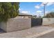 Cozy home featuring a gray brick wall, a gravel yard, and a gate providing charm and privacy at 1421 W Pasadena Ave, Phoenix, AZ 85013