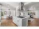 Open kitchen features an island cooktop, stainless vent hood, and seamless sightlines to the living and dining areas at 1421 W Pasadena Ave, Phoenix, AZ 85013