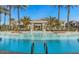 Large community pool surrounded by palm trees and lounge seating at 15221 N Clubgate Dr # 2096, Scottsdale, AZ 85254