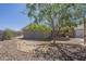 Landscaped backyard with decorative rock, mature tree, and brick wall for added privacy at 1530 E Loma Ln, Phoenix, AZ 85020