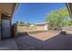 Inviting backyard patio featuring brick pavers, a privacy wall, and a detached garage under a clear blue sky at 1530 E Loma Ln, Phoenix, AZ 85020