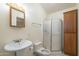 Well-lit bathroom with a pedestal sink, toilet, and glass-enclosed shower at 1530 E Loma Ln, Phoenix, AZ 85020