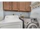 Functional laundry area featuring a dryer, a washing machine, and upper cabinets for storage at 1549 N La Rosa Dr, Tempe, AZ 85288
