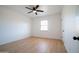 Bright bedroom showcasing a window and a ceiling fan, enhanced by wood-look laminate flooring at 1721 W Earll Dr, Phoenix, AZ 85015