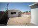 Backyard structure with white vertical siding and a concrete parking pad behind a metal gate at 1721 W Earll Dr, Phoenix, AZ 85015