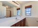 Well-lit bathroom featuring a vanity, large mirror, and window at 18182 W Desert Ln, Surprise, AZ 85388
