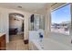 Relaxing bathroom showcasing a tub, shower, and large window, ideal for unwinding with neighborhood views at 18182 W Desert Ln, Surprise, AZ 85388