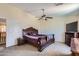 Cozy bedroom featuring neutral walls, a ceiling fan, and ample natural light from the window at 18182 W Desert Ln, Surprise, AZ 85388