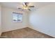 Neutral bedroom featuring ceiling fan, window, and carpet at 18182 W Desert Ln, Surprise, AZ 85388