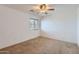 Neutral bedroom featuring ceiling fan, window, and carpet at 18182 W Desert Ln, Surprise, AZ 85388