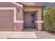 Welcoming front entrance featuring a covered porch, neutral paint colors, and a well-manicured yard at 18182 W Desert Ln, Surprise, AZ 85388