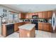 Well-equipped kitchen with granite countertops, wood cabinets, tile backsplash, and modern appliances at 18182 W Desert Ln, Surprise, AZ 85388