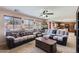 Comfortable living room with a plush sectional sofa, ceiling fan, and plenty of natural light at 18182 W Desert Ln, Surprise, AZ 85388