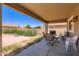Covered patio with table and chairs overlooking the backyard at 18182 W Desert Ln, Surprise, AZ 85388