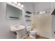 Well-lit bathroom featuring a pedestal sink, floating shelves, and a shower-tub combo at 19621 W Minnezona Ave, Litchfield Park, AZ 85340