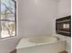 Bright bathroom featuring a soaking tub with a fireplace and a large window at 19621 W Minnezona Ave, Litchfield Park, AZ 85340