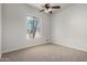 Bedroom featuring a ceiling fan, carpeted floor, and a large window at 19621 W Minnezona Ave, Litchfield Park, AZ 85340