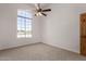 Bedroom with a ceiling fan, carpeted floor, and a large window at 19621 W Minnezona Ave, Litchfield Park, AZ 85340