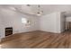 An open living room with wood floors, fireplace and large window creating an inviting atmosphere at 19621 W Minnezona Ave, Litchfield Park, AZ 85340