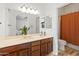Bright bathroom featuring a large mirror, wood cabinets, and a shower with orange curtain at 2150 E Bell Rd # 1088, Phoenix, AZ 85022