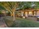 Serene backyard featuring a covered patio, an outdoor kitchen, and a spacious grassy area at 21575 E Twin Acres Ct, Queen Creek, AZ 85142