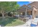 Expansive backyard with a custom outdoor kitchen, covered patio, fireplace and lush lawn at 21575 E Twin Acres Ct, Queen Creek, AZ 85142