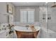 Elegant bathroom featuring a copper tub, marble tile, and bright natural light at 21575 E Twin Acres Ct, Queen Creek, AZ 85142