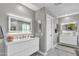 Bathroom with a modern vanity, lighted mirrors, double sinks, and light gray walls at 21575 E Twin Acres Ct, Queen Creek, AZ 85142