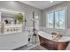 Well-lit bathroom featuring a soaking tub, marble floors, white cabinets and modern fixtures at 21575 E Twin Acres Ct, Queen Creek, AZ 85142