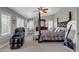 Bright primary bedroom featuring a four-poster bed, large windows, massage chair, and light walls at 21575 E Twin Acres Ct, Queen Creek, AZ 85142