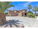 Beautiful two-story home with a spacious driveway, three-car garage, and mature palm trees at 21575 E Twin Acres Ct, Queen Creek, AZ 85142