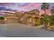 Elegant two-story home with a well-designed front entrance, landscaped gardens, and a spacious three-car garage at 21575 E Twin Acres Ct, Queen Creek, AZ 85142