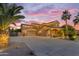 Charming home exterior with a spacious driveway, desert landscaping, and attractive architectural details at 21575 E Twin Acres Ct, Queen Creek, AZ 85142