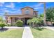 Charming two-story home with a covered porch, manicured lawn, and lush landscaping at 21575 E Twin Acres Ct, Queen Creek, AZ 85142