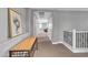 Well-lit upstairs hallway with neutral color scheme and classic bench at 21575 E Twin Acres Ct, Queen Creek, AZ 85142