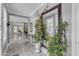 Inviting hallway with elegant marble floors and a mirror framed by beautiful plants at 21575 E Twin Acres Ct, Queen Creek, AZ 85142