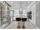 Modern kitchen with a marble island, sleek bar stools, and a climate-controlled wine storage unit at 21575 E Twin Acres Ct, Queen Creek, AZ 85142
