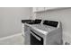 Functional laundry room features stainless steel washer and dryer and a granite countertop sink at 21575 E Twin Acres Ct, Queen Creek, AZ 85142