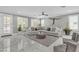 Bright living room with a large sectional, gray accents and marble floors at 21575 E Twin Acres Ct, Queen Creek, AZ 85142