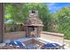 Inviting outdoor living space featuring a stone fireplace, perfect for cozy evenings and entertaining guests at 21575 E Twin Acres Ct, Queen Creek, AZ 85142