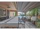Covered outdoor kitchen with bar seating overlooking the sparkling pool and lush landscaping at 21575 E Twin Acres Ct, Queen Creek, AZ 85142