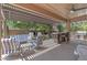 Spacious covered patio with comfortable seating, a bar, and a built-in grill, creating an ideal outdoor entertaining area at 21575 E Twin Acres Ct, Queen Creek, AZ 85142