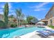 Lounge chairs by a sparkling pool, with nearby outdoor seating area at 21575 E Twin Acres Ct, Queen Creek, AZ 85142